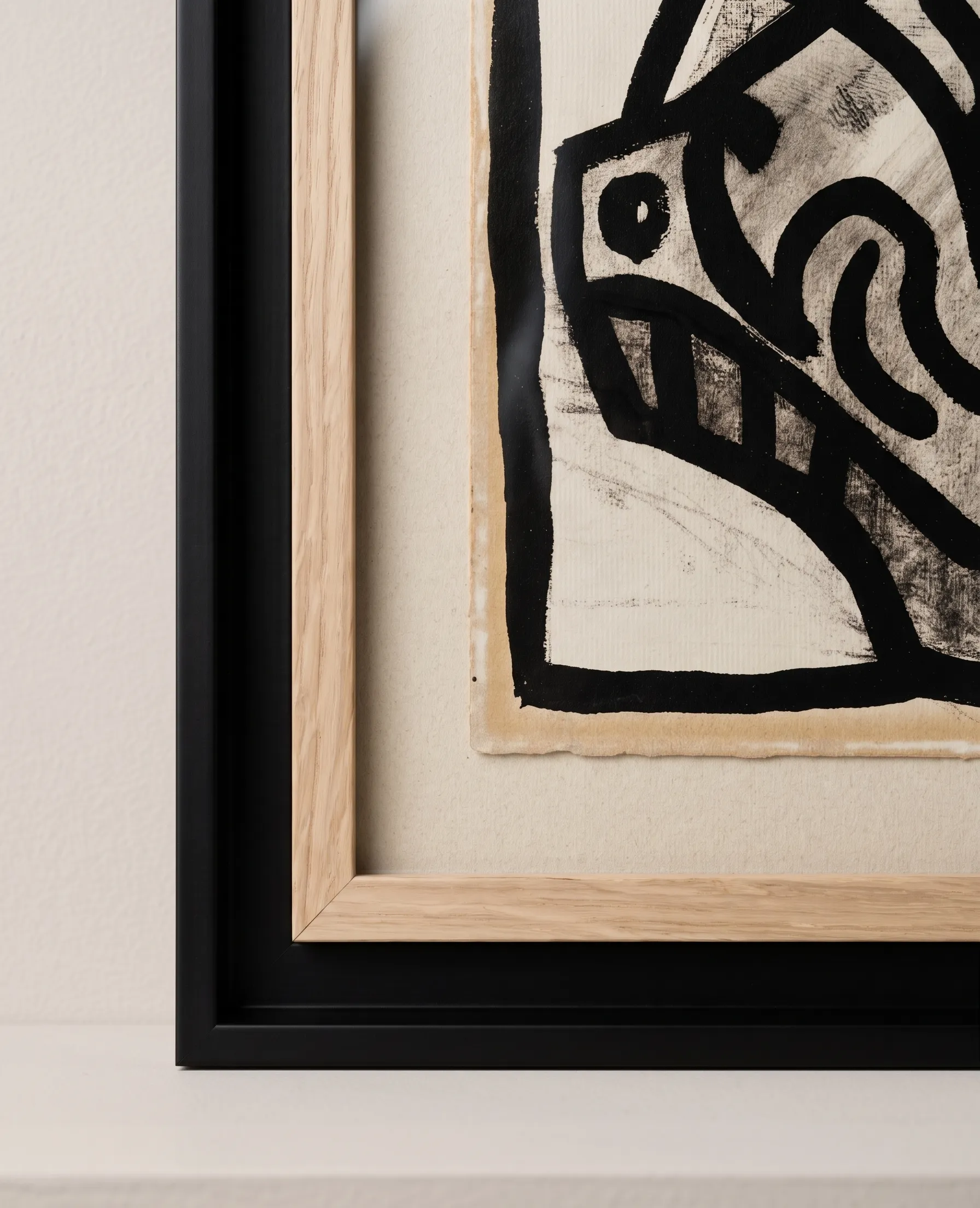 Détail du coin du cadre : bois clair à l'intérieur, cadre noir à l'extérieur, papier aux bords irréguliers