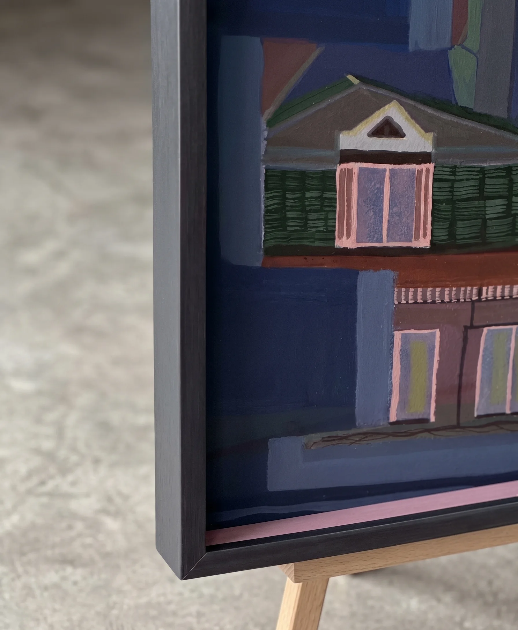 Détail d'un cadre noir profond, peinture pop d'architectures en bleu, vert et rose